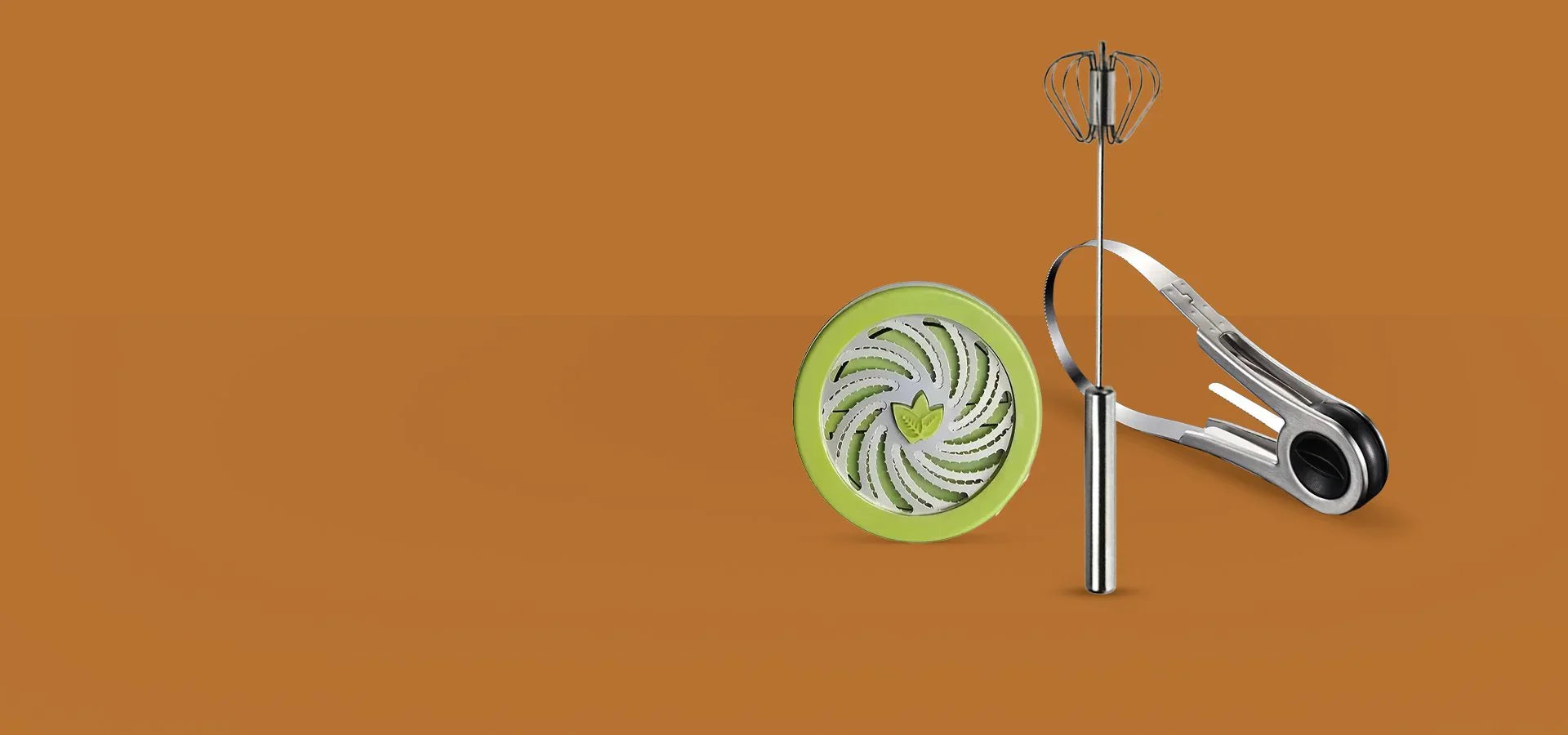 Комплект кухненски инструменти – метален тел за разбиване и зелен пластмасов ренде, на оранжев фон