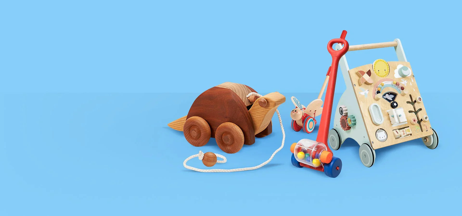 Дървени играчки за деца върху син фон, включващи дървено животно, проходилка и ръчна играчка